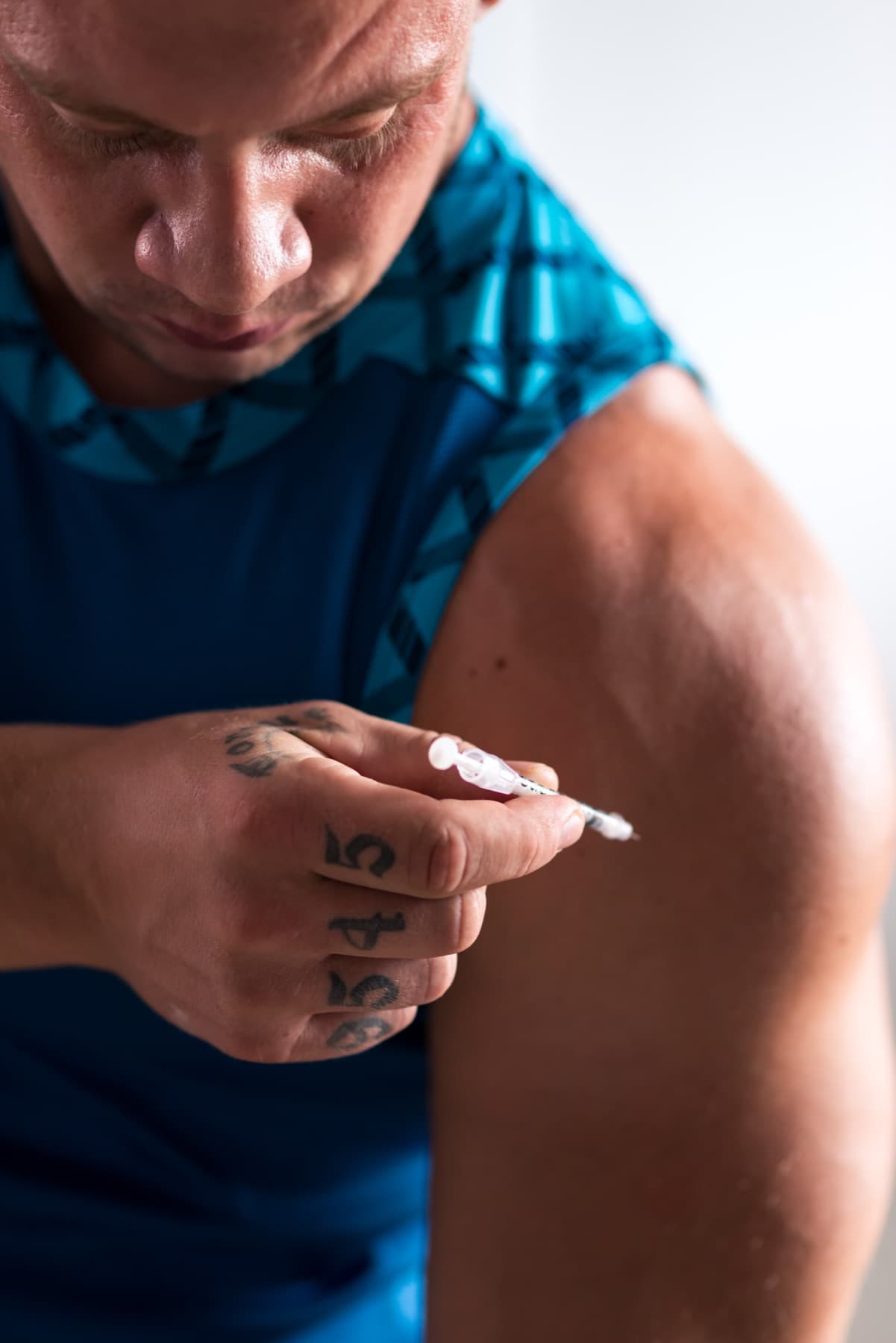 Athlete preparing an injection in the upper arm